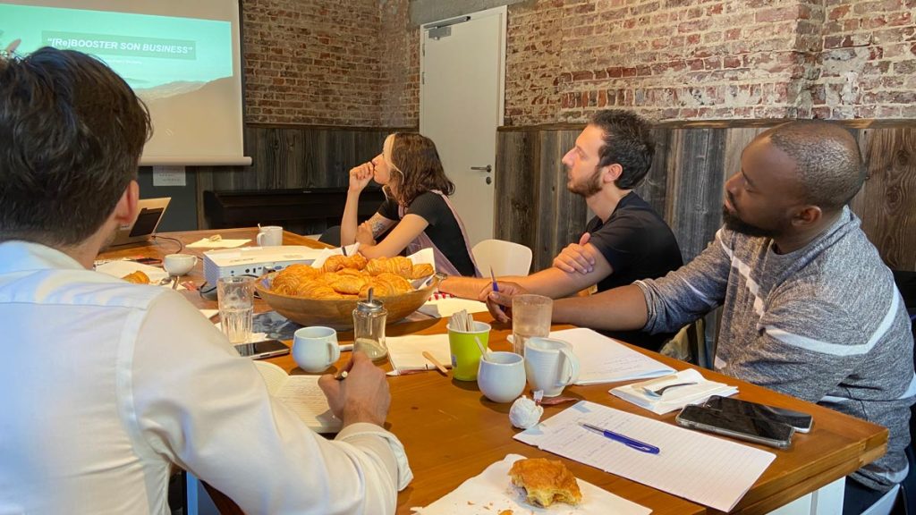 Groupe d'artistes professionnels en réunion pour un workshop entrepreneurial à Bruxelles.