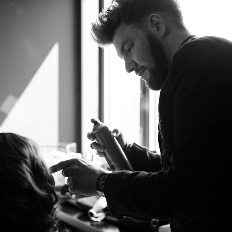 Portrait du coiffeur Olivier Lefèvre occupé à réaliser une coiffure en shooting mode.