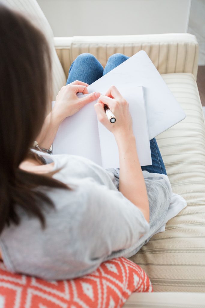 Une femme en train de prendre des notes dans son carnet.