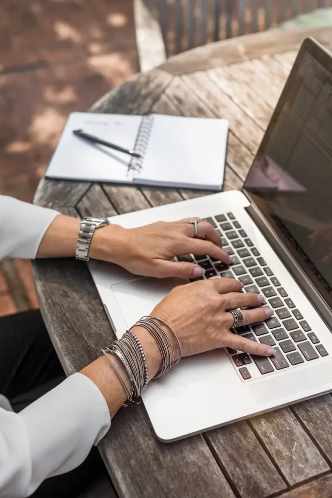 Une personne qui prends des notes sur son ordinateur portable Apple MacBook Pro